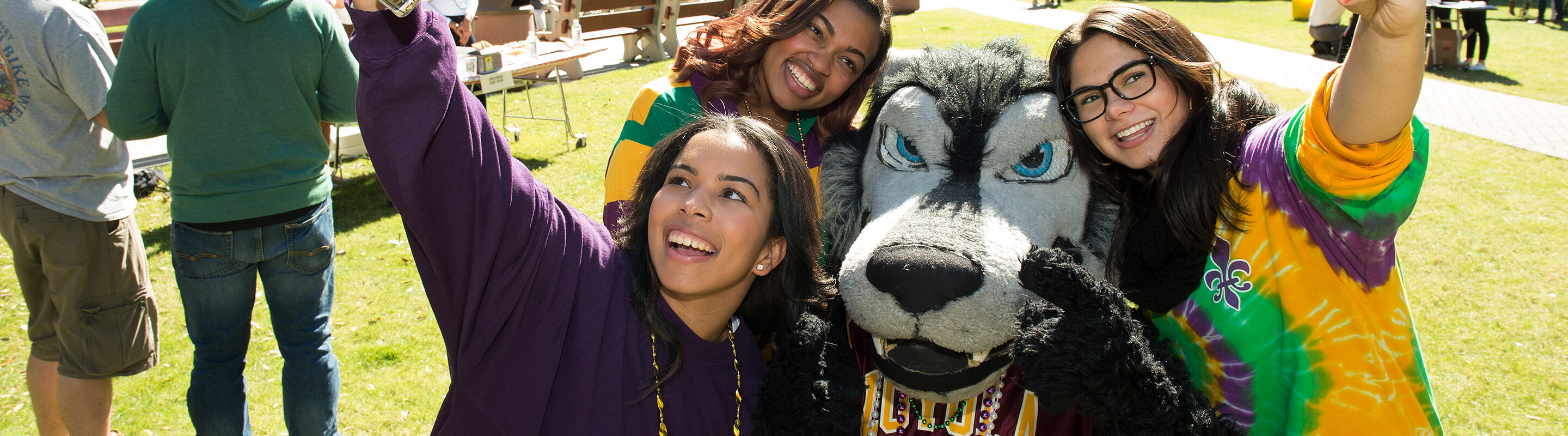 Group of students taking photo with mascot Havoc