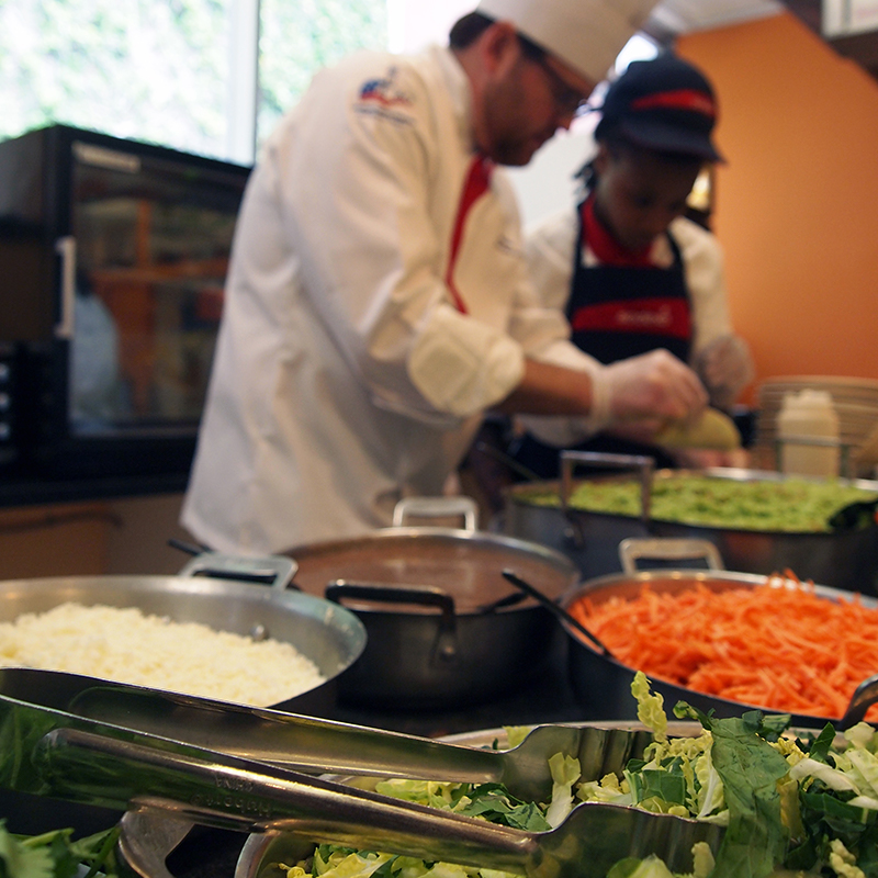 Two Loyola dining employees preparing salad