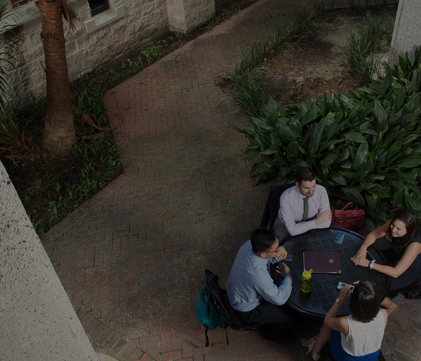 Students and professor discussing around outdoor table