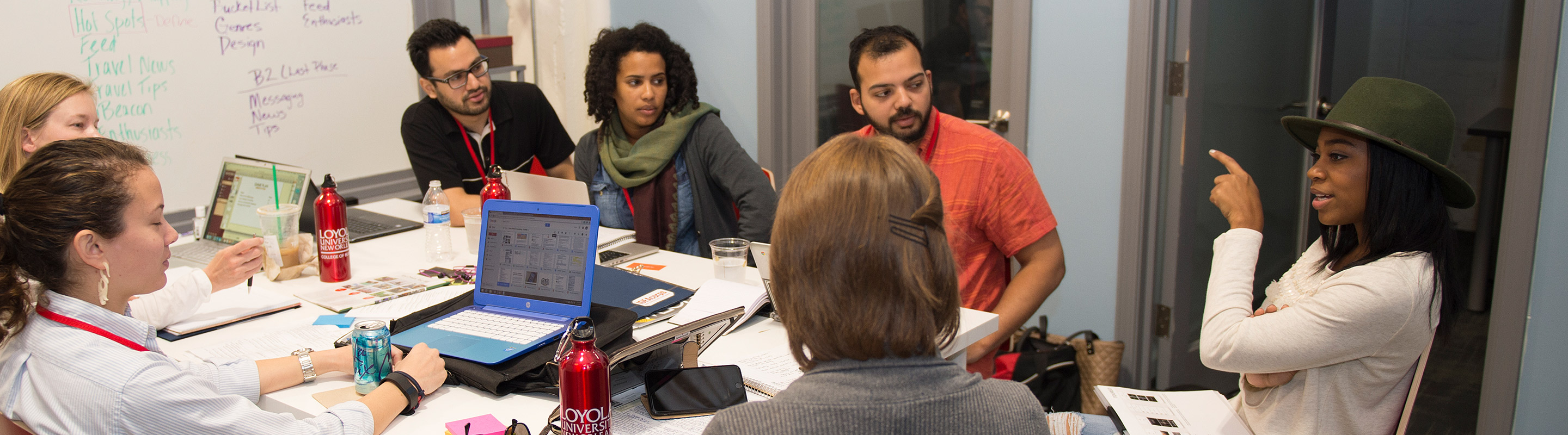 Students around table discussing project 