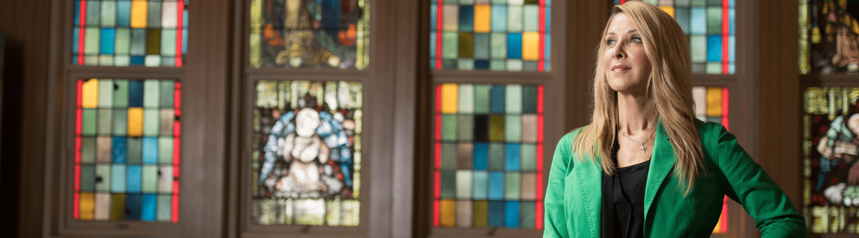 online master of pastoral studies student in front of a stained glass window.
