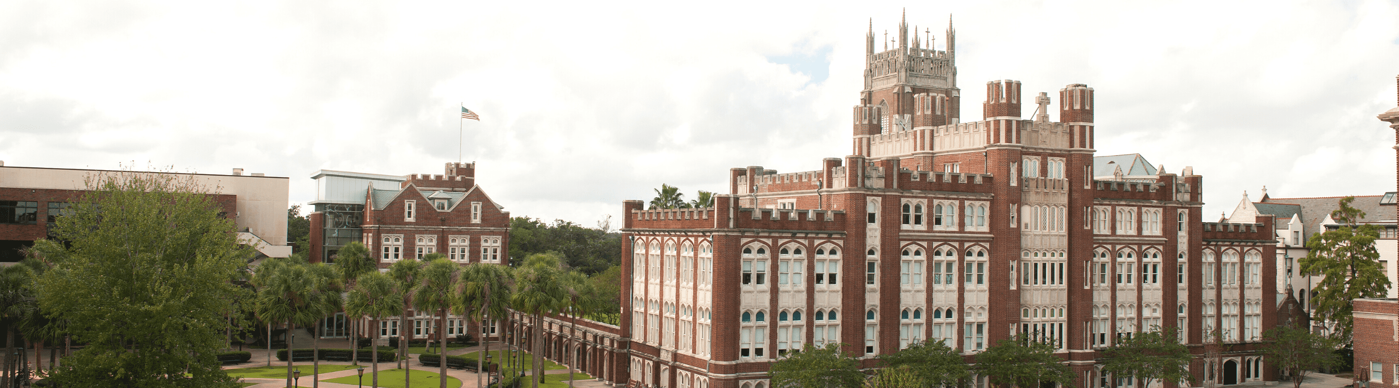 Wide angle view of Loyola's campus with a cloudy sky backdrop.