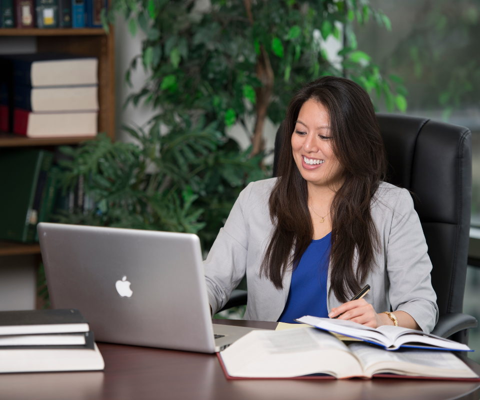 Online Master of Science in Marketing and Communications student working on an assignment on her laptop.