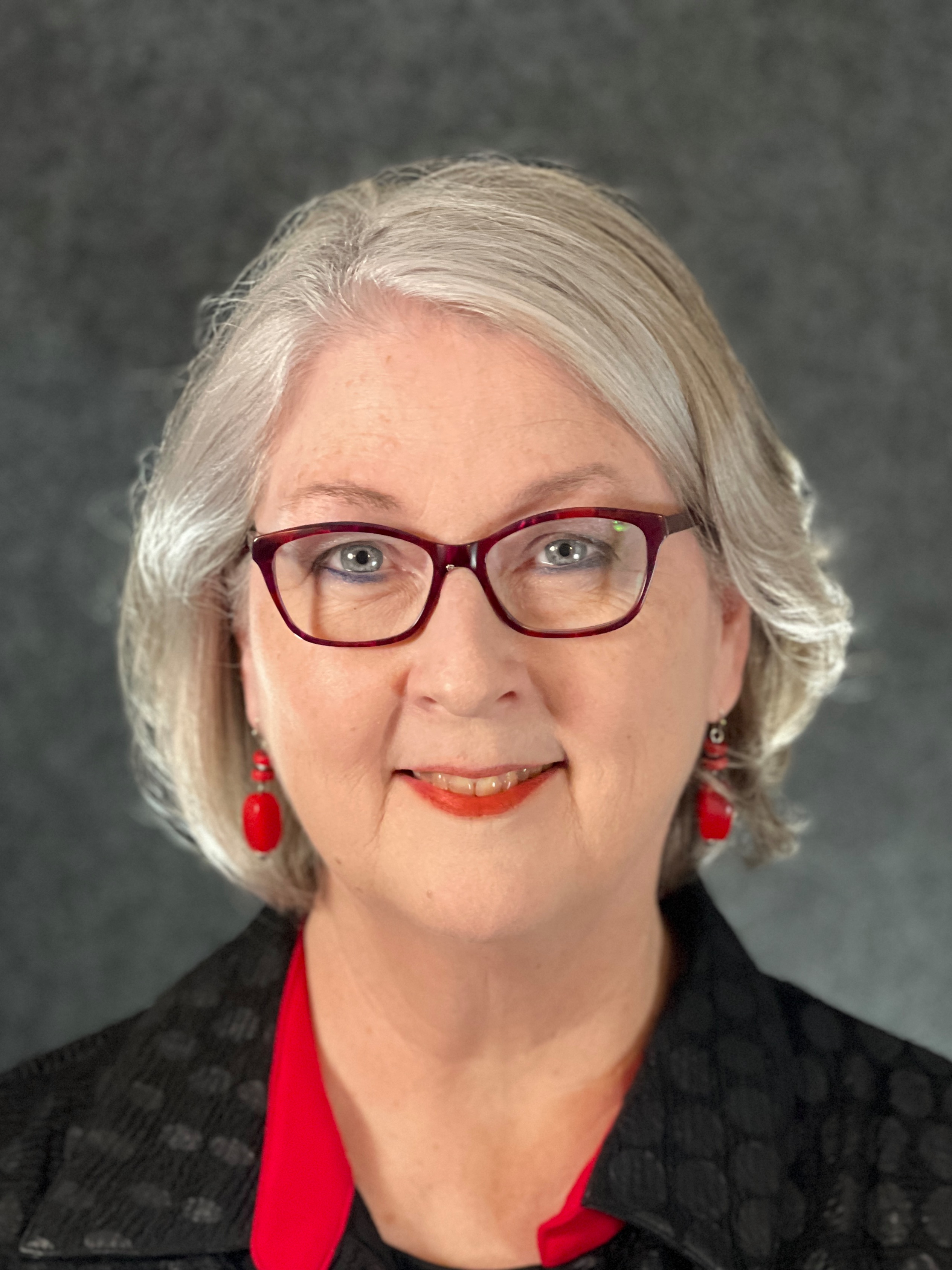 Woman, silver hair, glasses, black and red attire